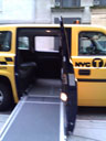 photo of a ramp extended outside of a yellow Nissan MV-1