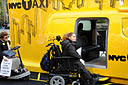 photo of photo of a woman in a wheelchair at an inaccessible entrance to the taxicab