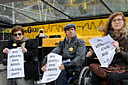 photo of group of 3 holding signs reading New York City Violates Civil Rights - Justice Department