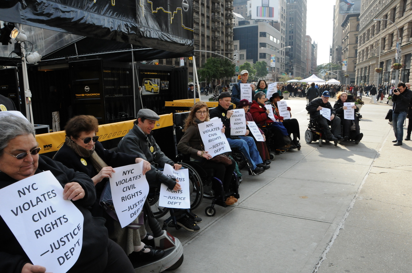 photo of demonstrators holding signs stating New York City Violates Civil Rights - Justice Department