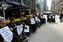 photo of demonstrators holding signs stating a Justice Department quote, New York City Violates Civil Rights