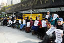 photo of two wheelchair users holding signs