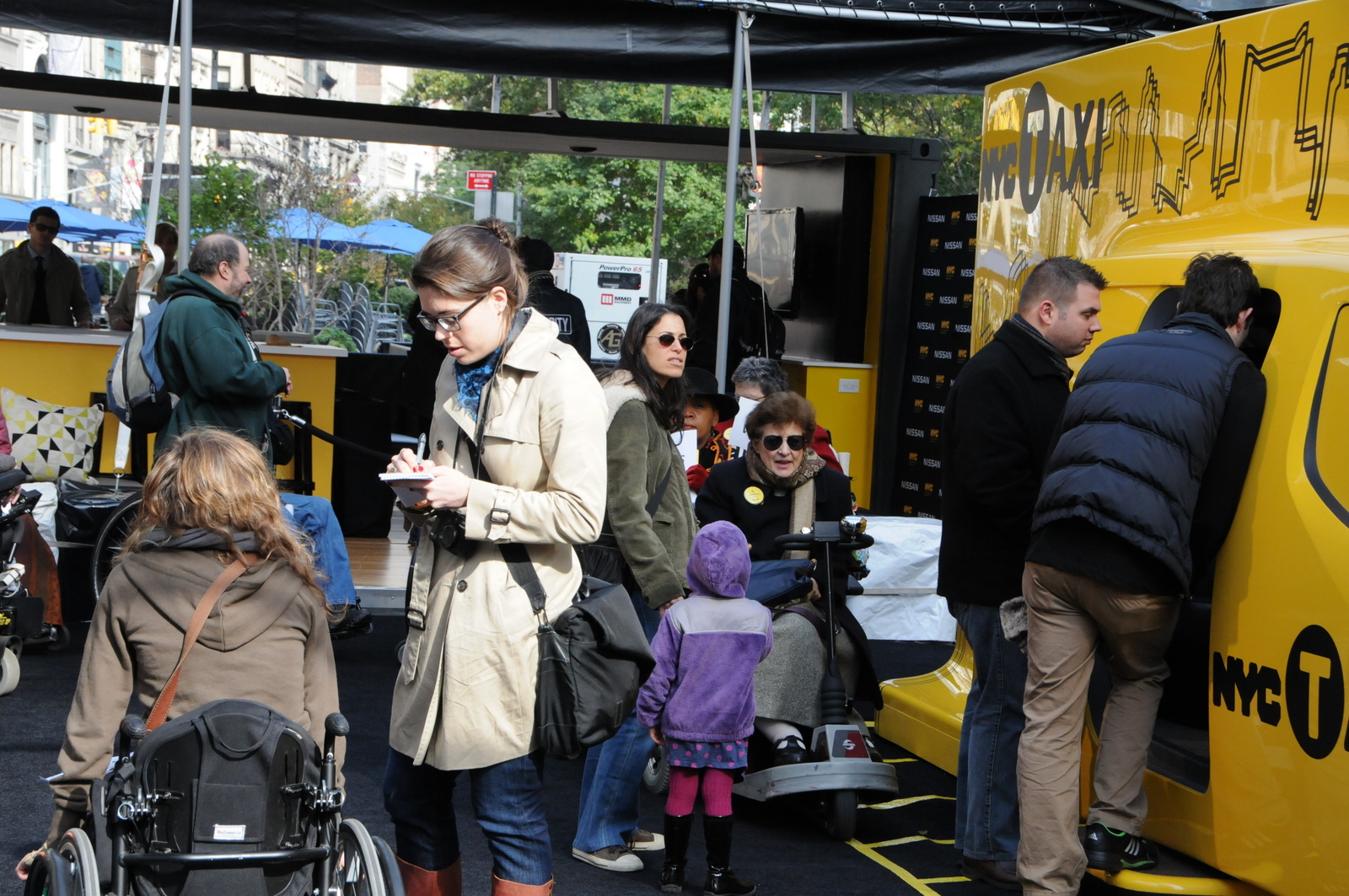 photo of demonstrators in wheelchairs and lookers-on at inaccessible Taxi