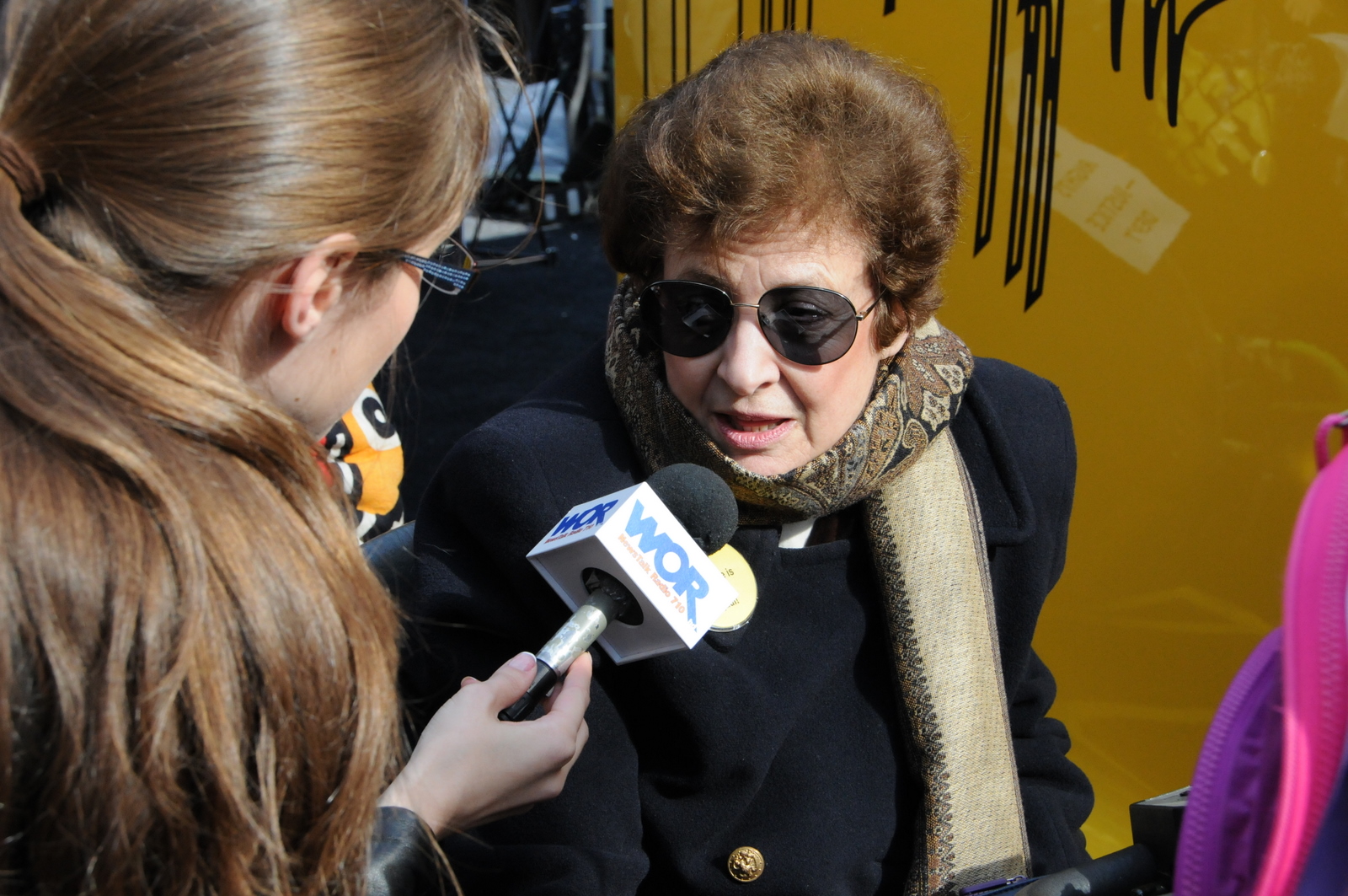 photo of a demonstrator in a wheelchairs being interviewed by a reporter